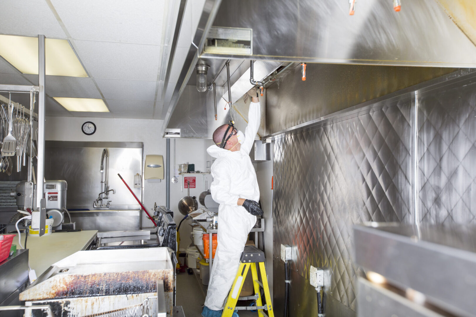 Workers repairing commercial kitchen ventilation system