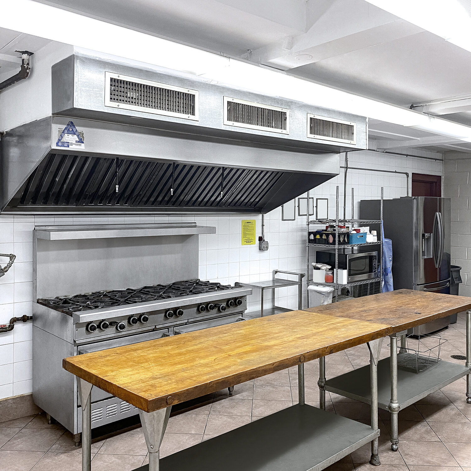 Commercial kitchen with range, hood, and prep table