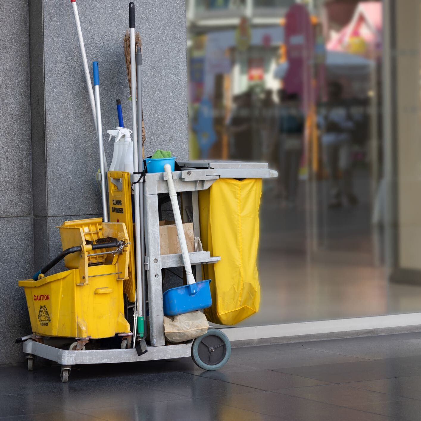 Janitorial cart with mop bucket and supplies
